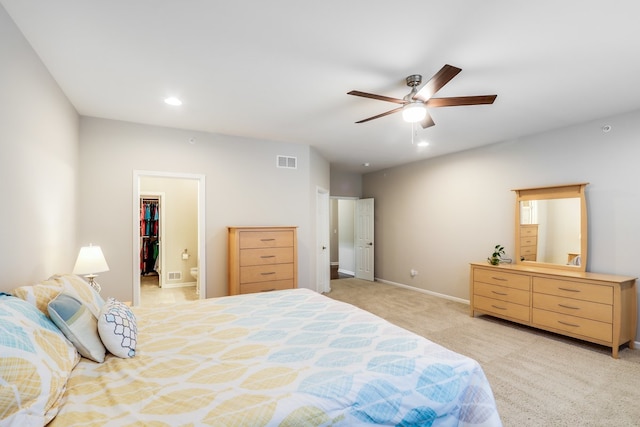 carpeted bedroom featuring a walk in closet, ceiling fan, and a closet