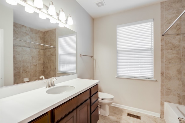 full bathroom featuring toilet, tile patterned flooring, tiled shower / bath, and vanity