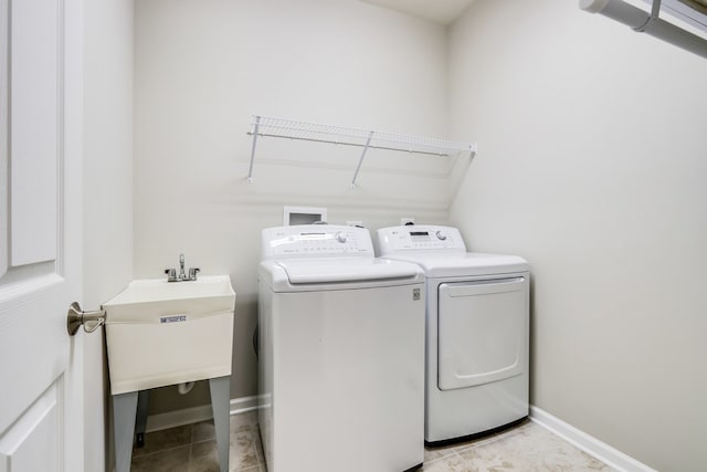 washroom featuring washer and dryer, sink, and light tile patterned floors