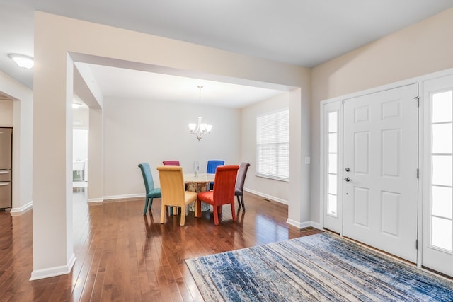 foyer with a notable chandelier and dark hardwood / wood-style flooring