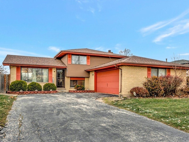 tri-level home with a garage and a front lawn