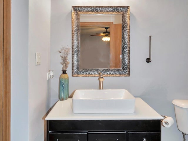 bathroom with toilet, ceiling fan, and vanity