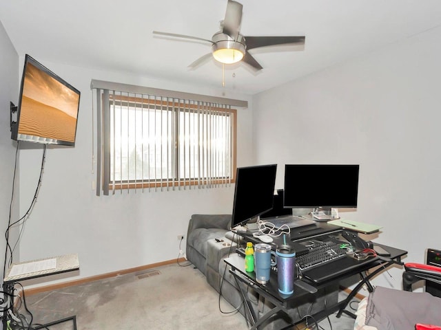 carpeted home office featuring ceiling fan