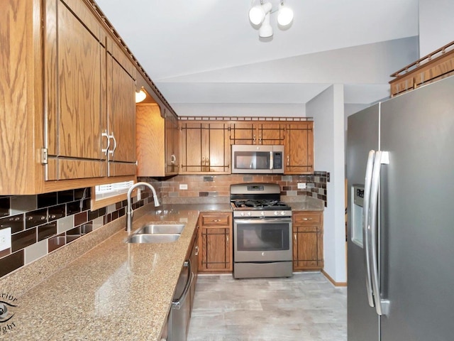 kitchen featuring sink, tasteful backsplash, lofted ceiling, and appliances with stainless steel finishes