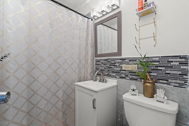 bathroom featuring curtained shower, vanity, tile walls, and toilet