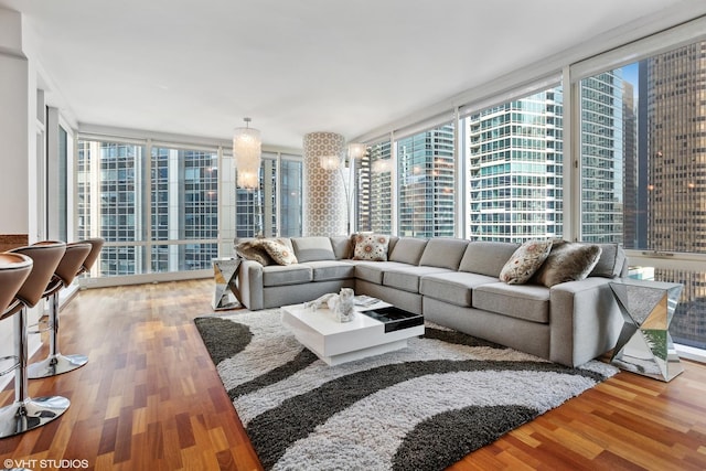 living room featuring hardwood / wood-style floors, a wall of windows, and a wealth of natural light