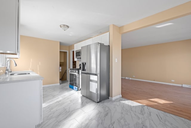 kitchen featuring white cabinets, stainless steel appliances, light hardwood / wood-style floors, and sink