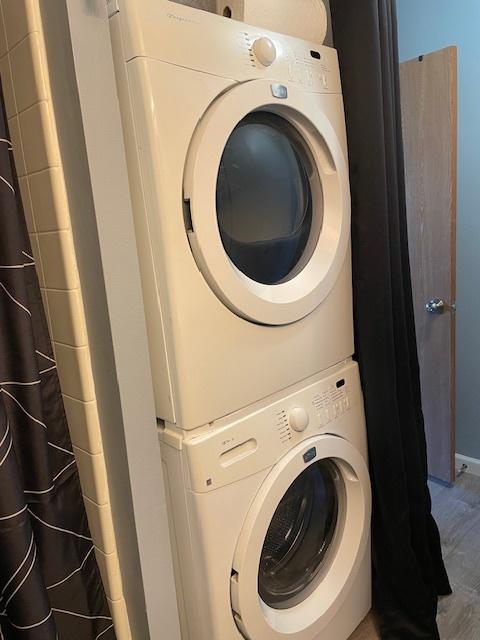 clothes washing area featuring stacked washer / dryer