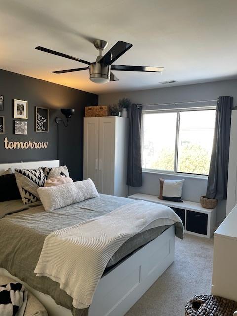 bedroom with ceiling fan and light colored carpet