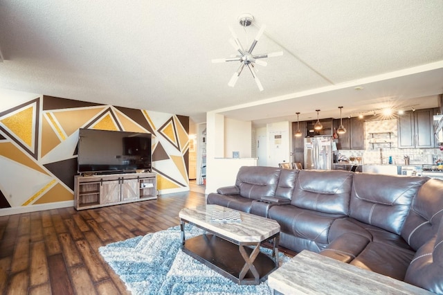 living room with a textured ceiling, dark hardwood / wood-style floors, and ceiling fan