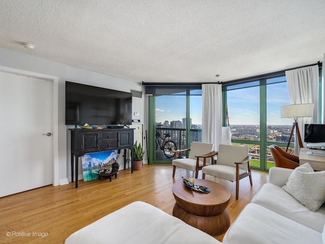 living room with hardwood / wood-style floors, a textured ceiling, and expansive windows