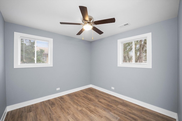 empty room featuring wood-type flooring, plenty of natural light, and ceiling fan