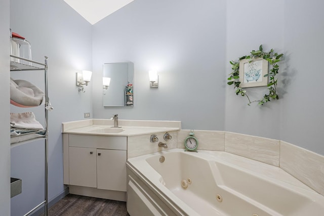 bathroom with vanity, hardwood / wood-style floors, a bathtub, and vaulted ceiling