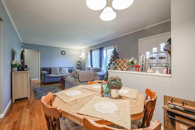 dining area featuring wood-type flooring and ornamental molding