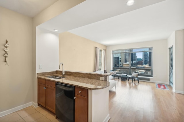 130 N Garland Ct Unit 2608, Chicago, IL 60602 - kitchen featuring black dishwasher, brown cabinetry, stone countertops, a peninsula, and light wood-style floors