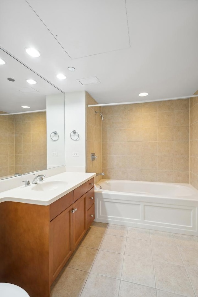 bathroom with tile patterned flooring, vanity, tiled shower / bath, and tile walls