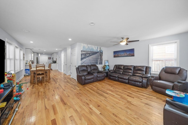 living room with ceiling fan and light wood-type flooring