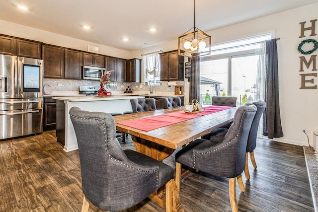 dining room with dark hardwood / wood-style floors, a wealth of natural light, and sink