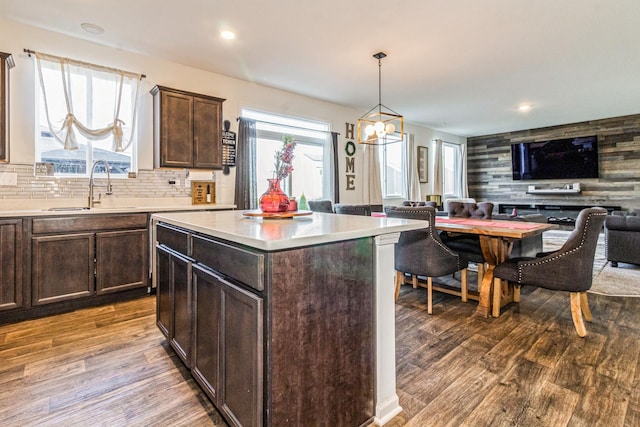 kitchen featuring dark brown cabinetry, sink, a center island, hanging light fixtures, and hardwood / wood-style floors