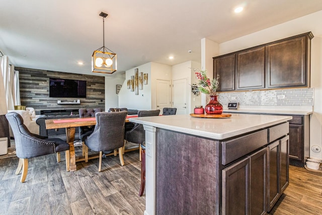 kitchen with a center island, dark wood-type flooring, hanging light fixtures, a chandelier, and dark brown cabinets