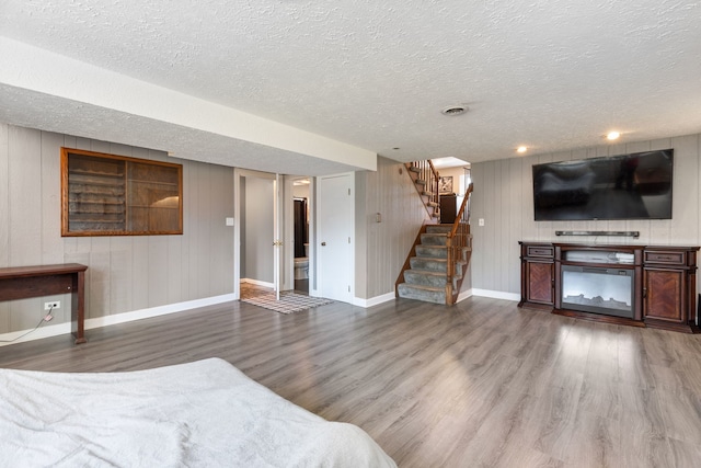 unfurnished bedroom with hardwood / wood-style flooring, a fireplace, and a textured ceiling