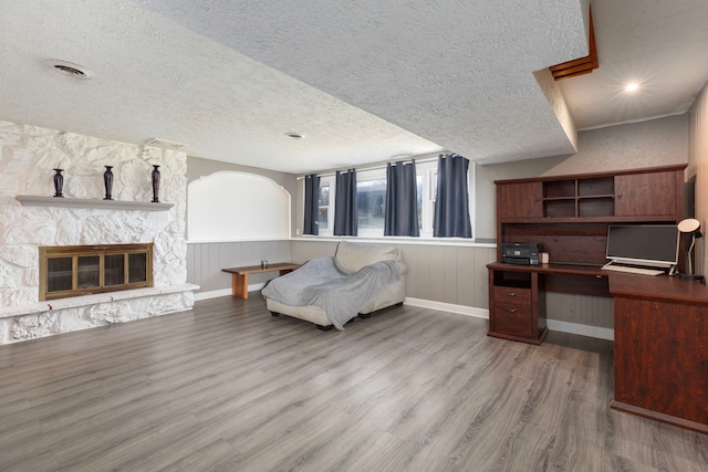 interior space featuring wood-type flooring, a fireplace, and a textured ceiling