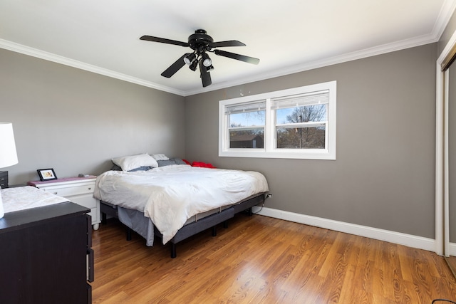 bedroom featuring hardwood / wood-style flooring, crown molding, and ceiling fan