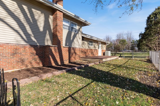 view of side of property with a yard and a deck