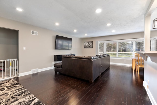 living room featuring dark hardwood / wood-style flooring and a textured ceiling