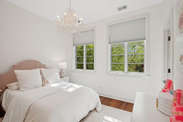 bedroom featuring hardwood / wood-style floors and an inviting chandelier