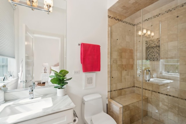 bathroom featuring toilet, vanity, and walk in shower