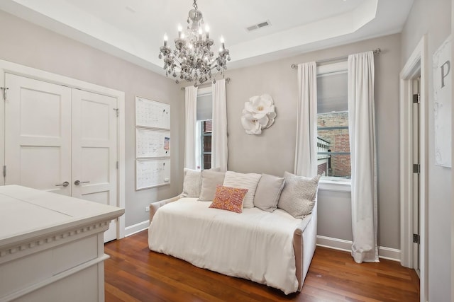 bedroom with a closet, dark wood-type flooring, and a notable chandelier