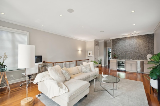 living room with hardwood / wood-style flooring, beverage cooler, ornamental molding, and sink