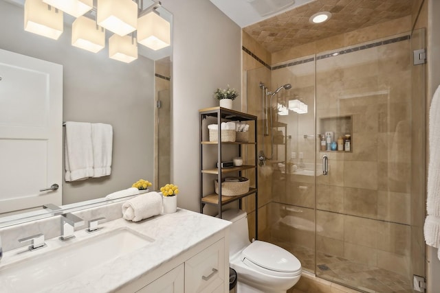 bathroom with vanity, toilet, and a shower with shower door