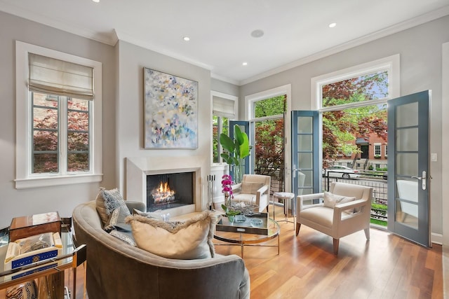 sitting room with french doors, light hardwood / wood-style floors, a wealth of natural light, and crown molding