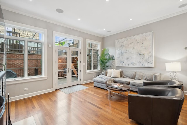 living room featuring light hardwood / wood-style floors, ornamental molding, and french doors