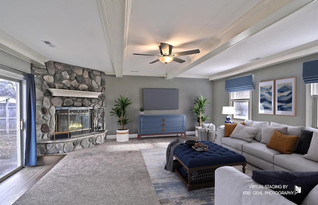 living room with a stone fireplace, ceiling fan, hardwood / wood-style floors, and a healthy amount of sunlight