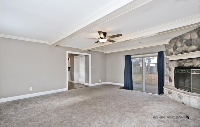 unfurnished living room with carpet, ceiling fan, crown molding, beamed ceiling, and a stone fireplace