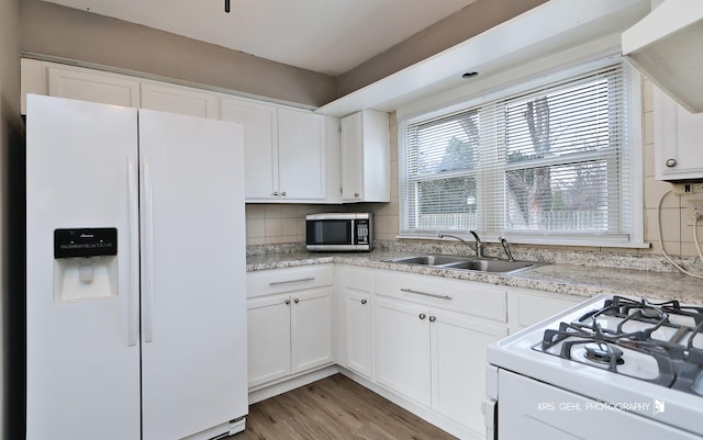 kitchen with sink, white cabinets, white appliances, and light wood-type flooring