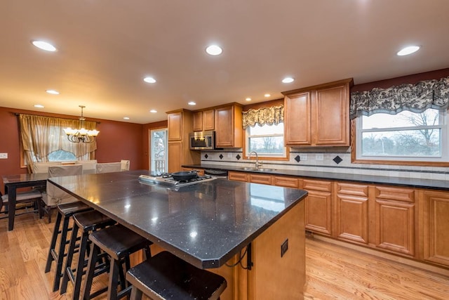 kitchen featuring sink, a center island, light hardwood / wood-style flooring, and appliances with stainless steel finishes