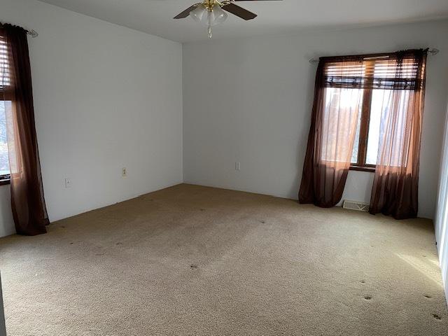 carpeted empty room with ceiling fan