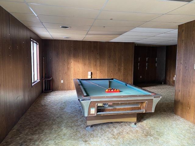 game room with wooden walls, a drop ceiling, carpet floors, and pool table