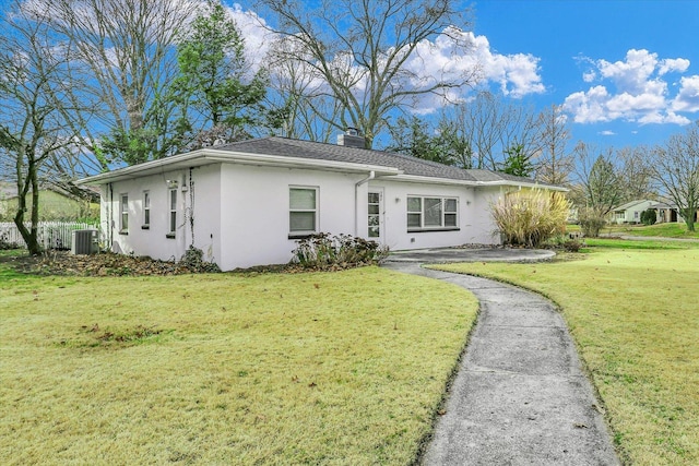 ranch-style house featuring central AC and a front yard