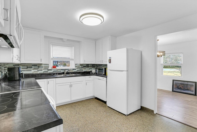 kitchen with decorative backsplash, white appliances, plenty of natural light, and sink