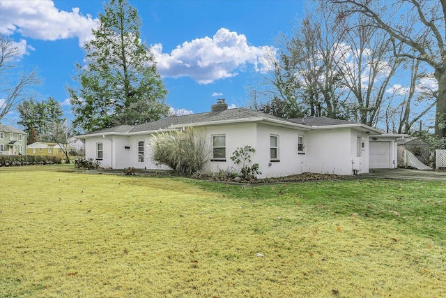 rear view of property with a yard and a garage