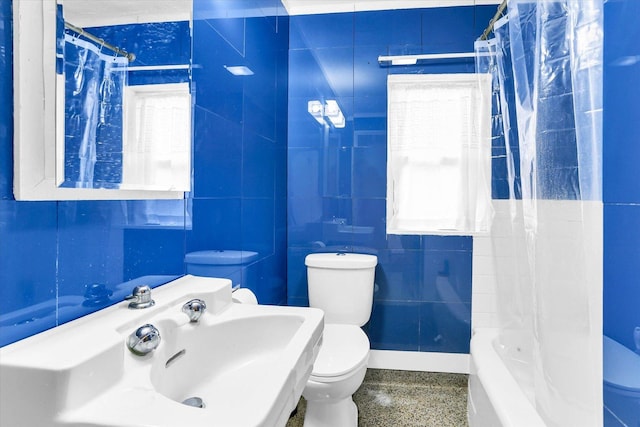 full bathroom featuring sink, shower / bath combination with curtain, tile walls, and toilet