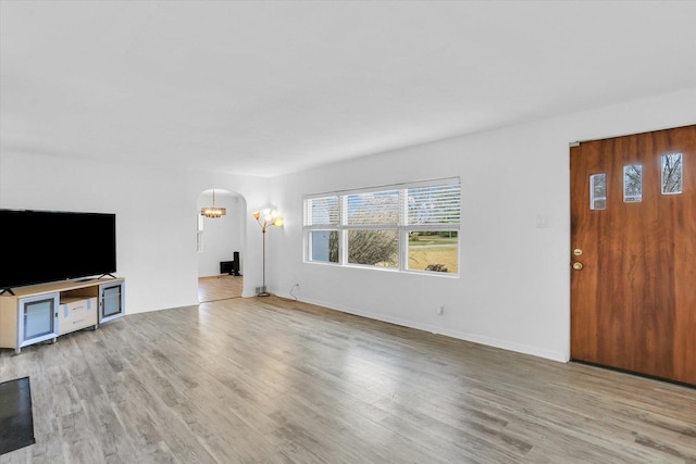 unfurnished living room with light hardwood / wood-style floors and an inviting chandelier