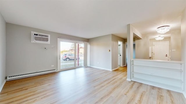 empty room with a wall mounted AC, a chandelier, a baseboard radiator, and light wood-type flooring