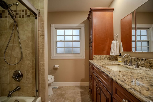 full bathroom featuring tile patterned floors, vanity, toilet, and tiled shower / bath combo