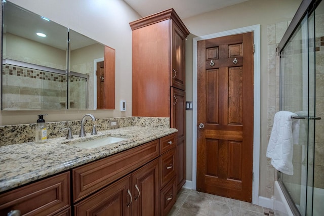 bathroom featuring shower / bath combination with glass door, tile patterned flooring, and vanity